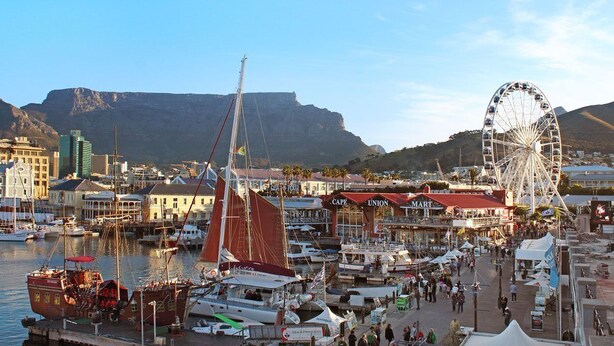A marina with boats, a Ferris wheel, and buildings in the background. - Sandringham 55 - Studio Apartment, Sleeps 2 (Cape Town)