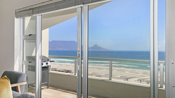 Ein Balkon mit Blick auf den Strand und den Ozean.