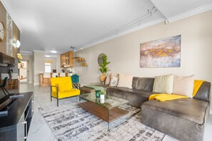 Un salon moderne avec un canapé, des fauteuils et une table basse.