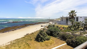 A coastal property with a beach, a modern house, and a view of the ocean. - Villa Kyma - Six Bedroom House, Sleeps 12 (Cape Town)