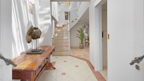 A modern interior with a wooden bench, a staircase, and a potted plant. - Villa Kyma - Six Bedroom House, Sleeps 12 (Cape Town)