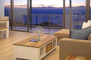 Enjoy a serene ocean view from the comfort of this stylish living space, featuring a spacious sofa and modern coffee table.