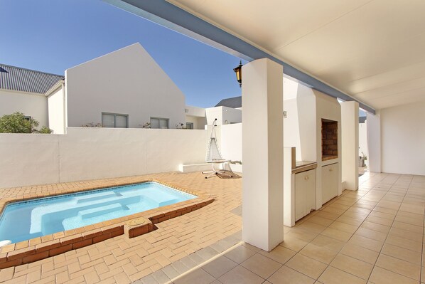 Relax by the pool surrounded by a pergola and a self-contained kitchen area.