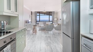 Eine moderne Küche mit Blick, ausgestattet mit einem Edelstahlkühlschrank, einem eingebauten Ofen und einem Essbereich mit Aussicht.