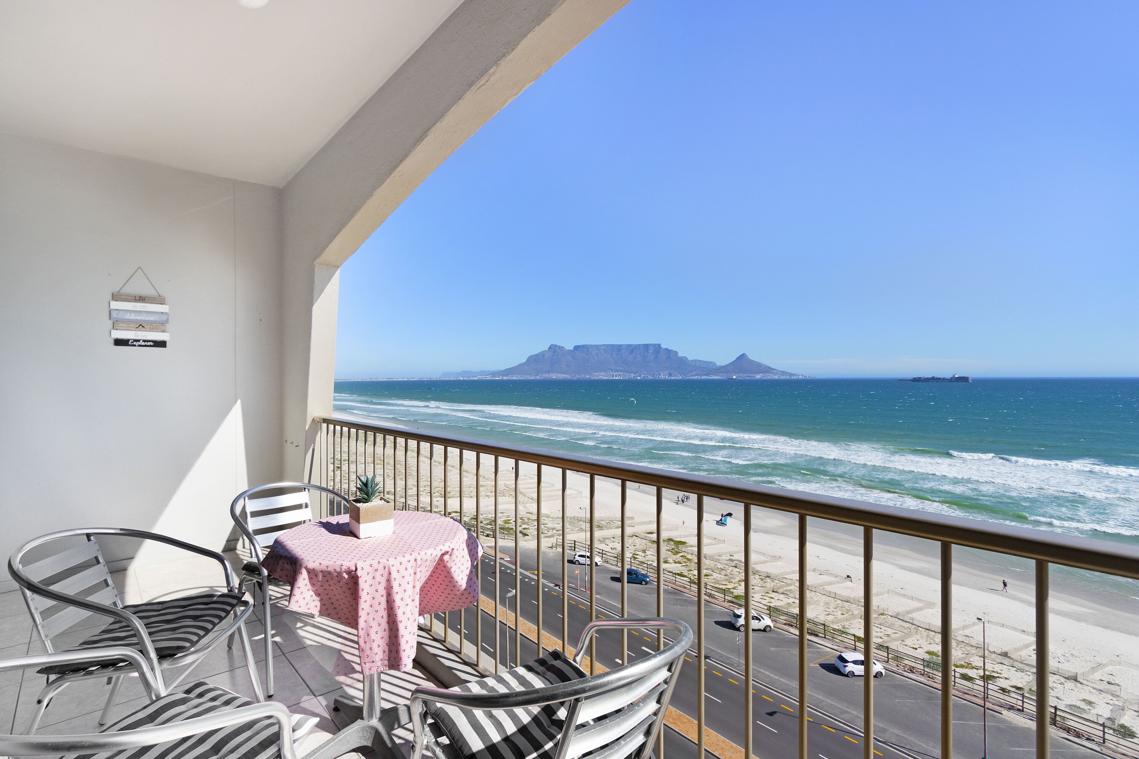 A balcony with a view of the ocean and a mountain.