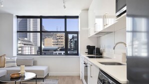 Eine moderne Küche mit großem Fenster, integriertem Backofen und Geschirrspüler.