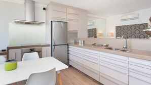 Een moderne keuken met een roestvrijstalen koelkast, een inbouwoven en een gasfornuis.
