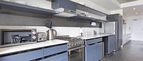 A modern kitchen with a built-in oven, a microwave, and a gas stove.