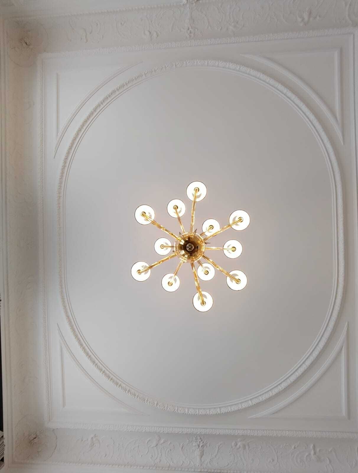 A ceiling with a central chandelier.