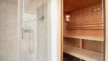 Una sauna con porta in vetro, panche di legno e un orologio a parete.