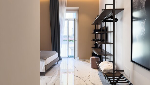 A modern bedroom with a bed, a large window, a wardrobe, and a marble floor. - InSogno Suites (Naples)