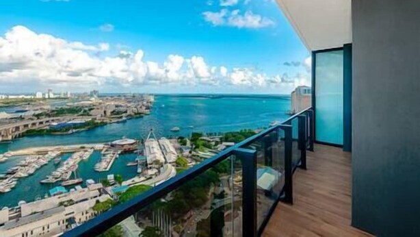 A balcony with a view of a marina and a cityscape.