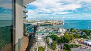 A high-rise building with a balcony overlooking a marina and cityscape. - Cozy 1 BD Apartment in Downtown #2415 (Miami)