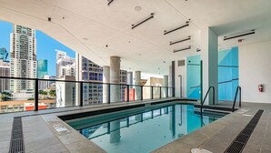 An indoor swimming pool with a city view, clear ceiling, and modern design. - Cozy 1 BD Apartment in Downtown #2415 (Miami)