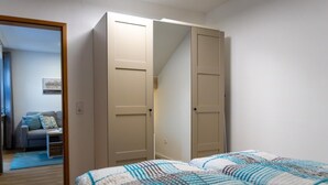 Une chambre à coucher avec un lit, une armoire et un miroir.