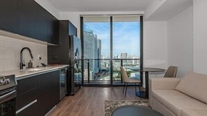 A modern apartment with a kitchen, a dining area, and a sofa. - Modern and Spacious Studio in Downtown #2207 (Miami)