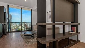 A modern living room with a large window, a round table, and built-in shelving. - Modern and Spacious Studio in Downtown #2207 (Miami)