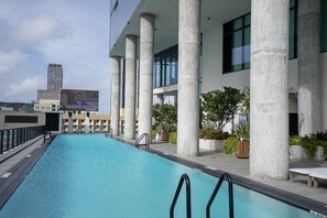 Une piscine offrant une vue sur des bâtiments modernes et un ciel dégagé.