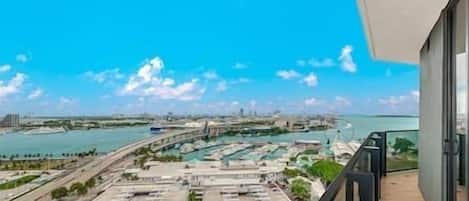 Un hôtel de grande hauteur doté d’un balcon donnant sur une marina et un pont.