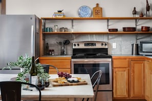 Une cuisine avec des meubles en bois, un réfrigérateur en acier inoxydable, une cuisinière et un four à micro-ondes.