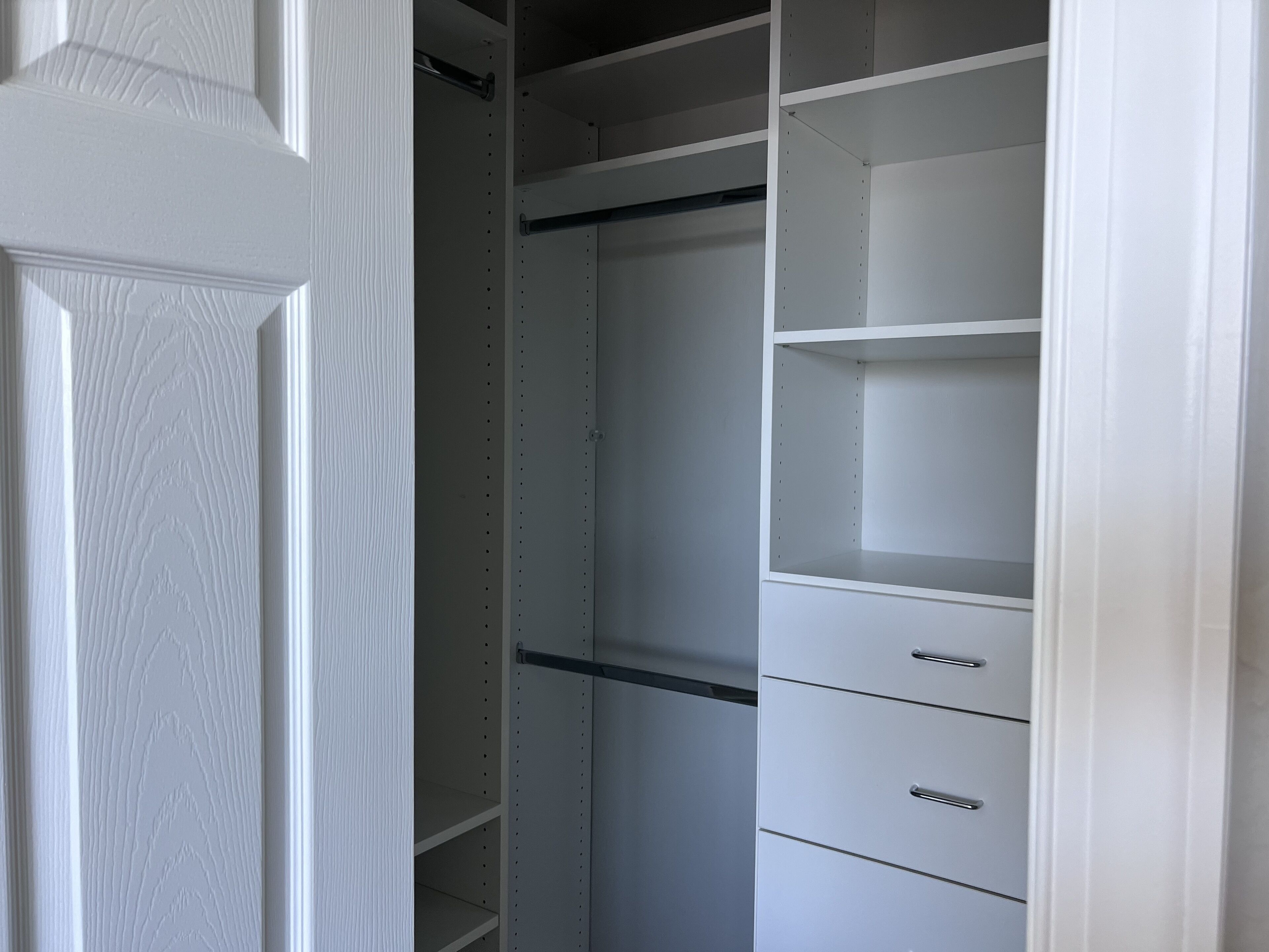 A white closet with multiple shelves and drawers.