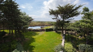 A lush green landscape with a pond, trees, and a stone wall. - 8 Bedroom Luxury Country Mansion in Galway (Costelloe)