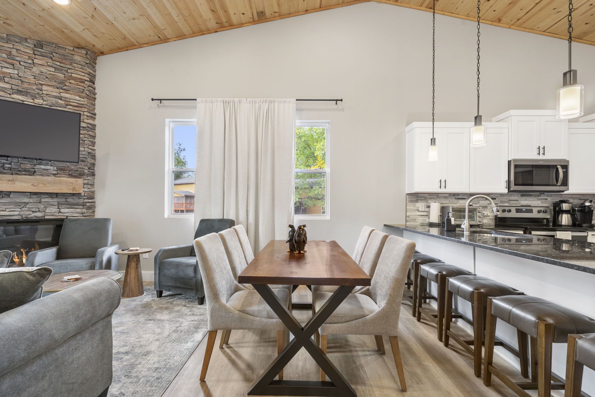 A modern kitchen with white cabinets, a built-in microwave, and a large island with bar stools.