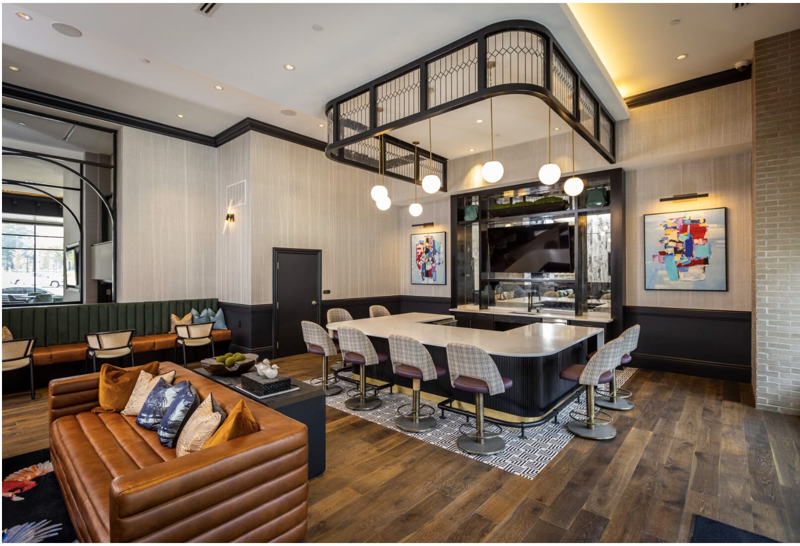 A modern interior with a curved staircase, a central island with bar stools, a leather sofa, and a dining area.