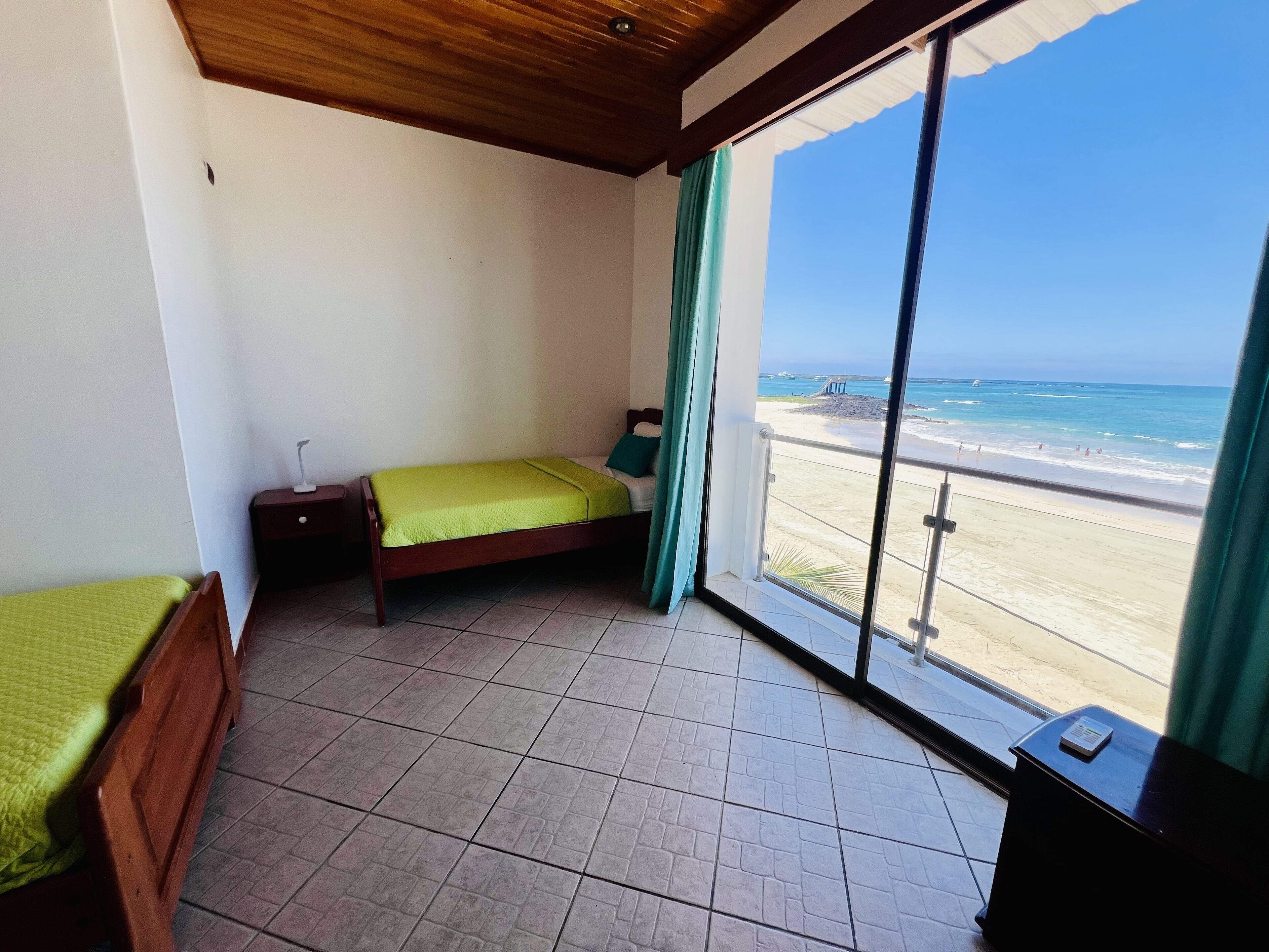 Una habitación con cama, mesita de noche y vista al mar.