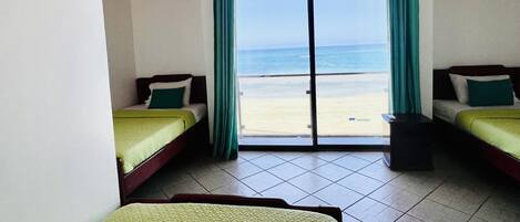 Ein Zimmer mit zwei Betten, Meerblick und Holzboden.