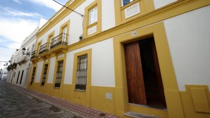 A yellow building with a number '29' on the door, a wooden door, and a window with a metal grill. - 200 Livingtarifa Drago (Tarifa)