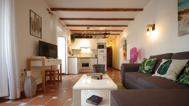 A living room with a brown sofa, a white coffee table, and a TV on a wooden stand. - 200 Livingtarifa Drago (Tarifa)