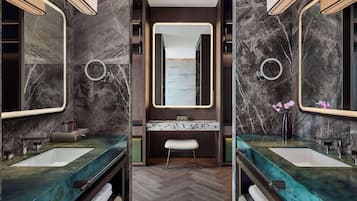 A modern bathroom with two sinks, marble countertops, and large mirrors.
