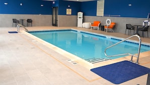 Piscina interior con señal de prohibido bucear, sillas de descanso y zona junto a la piscina.
