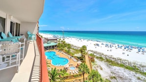 A balcony with a view of a beach and a pool area. - Hidden Dunes 602 (Panama City Beach)