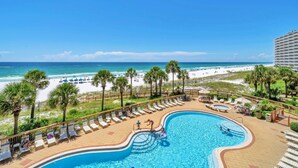 Ein Poolbereich eines Resorts mit Blick auf den Strand und den Ozean.