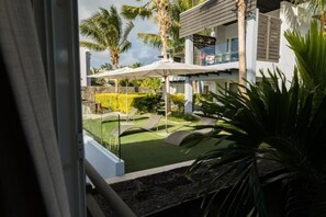 Enjoy the serene garden oasis with a gazebo, lush greenery, and a spacious outdoor living area.