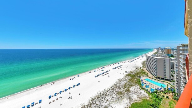 A beach resort with a pool, beach umbrellas, and a view of the ocean. - Hidden Dunes 1704 (Panama City Beach)