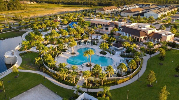 A resort with a large central pool, multiple buildings, and surrounding greenery. - Solara Resort -  5 bedrooms, Private Pool - FROZEN & HARRY POTTER - DISNEY AREA (Kissimmee)