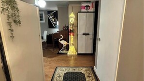 Un pasillo con un tapete estampado, una lámpara decorativa y un armario blanco al fondo.