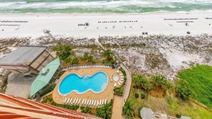 Een resort met een zwembad, ligbedden en uitzicht op de oceaan.