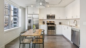 Eine moderne Küche mit weißen Schränken, Edelstahlgeräten und einem Holzespeisetisch.