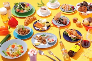 Una mesa con diversos alimentos y bebidas, como ensaladas, sándwiches y pasteles.