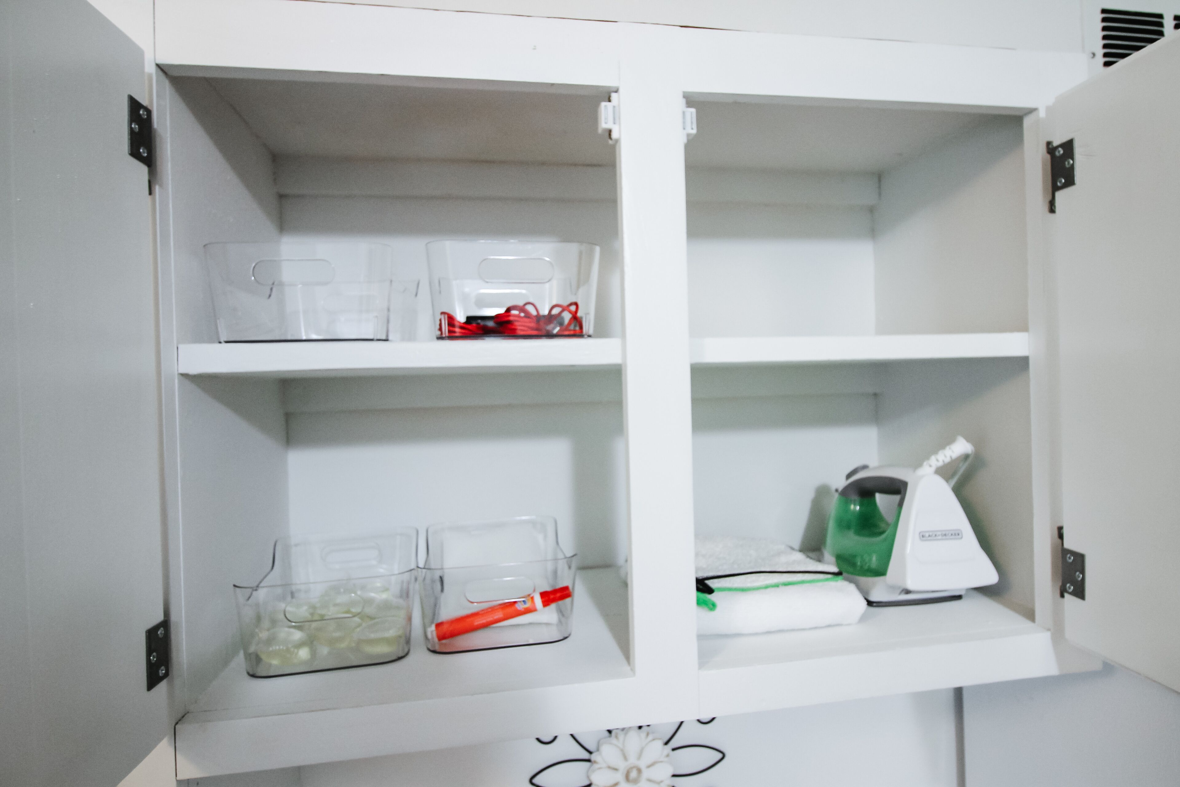 Een witte kast met transparante opbergbakken, gevuld met verschillende spullen.
