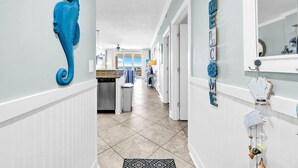 A hallway with a seahorse decoration, a view to the outside, and a wall with nautical-themed decor. - Ocean Villa 802 (Panama City Beach)