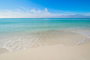 Una spiaggia con acque turchesi cristalline e una riva sabbiosa.