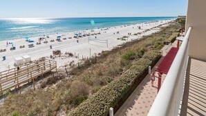 A beach view from a balcony with a clear sky, a sandy beach, and a few umbrellas. - Majestic Beach Towers 1-314 (Panama City Beach)