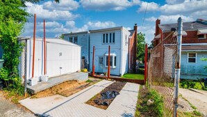 A residential area with a white utility shed, a blue house, and a fenced yard. - Quiet DC Retreat | 3BR | Sleeps 8 (Washington)