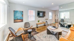 A modern living room with a sofa, chairs, a coffee table, and artwork on the walls. - Quiet DC Retreat | 3BR | Sleeps 8 (Washington)