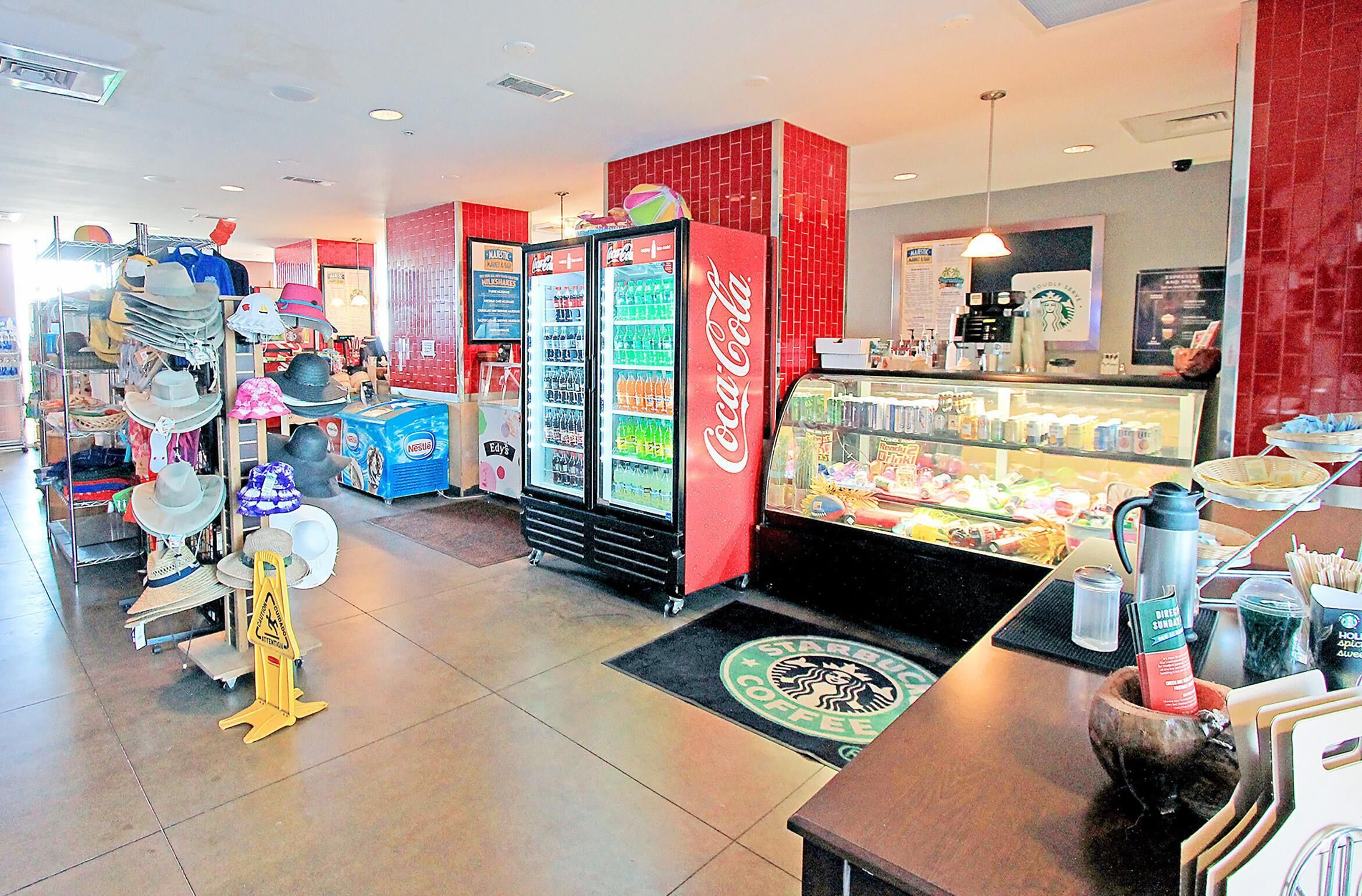 Un magasin qui vend une grande variété de chapeaux et qui possède un réfrigérateur Coca-Cola.
